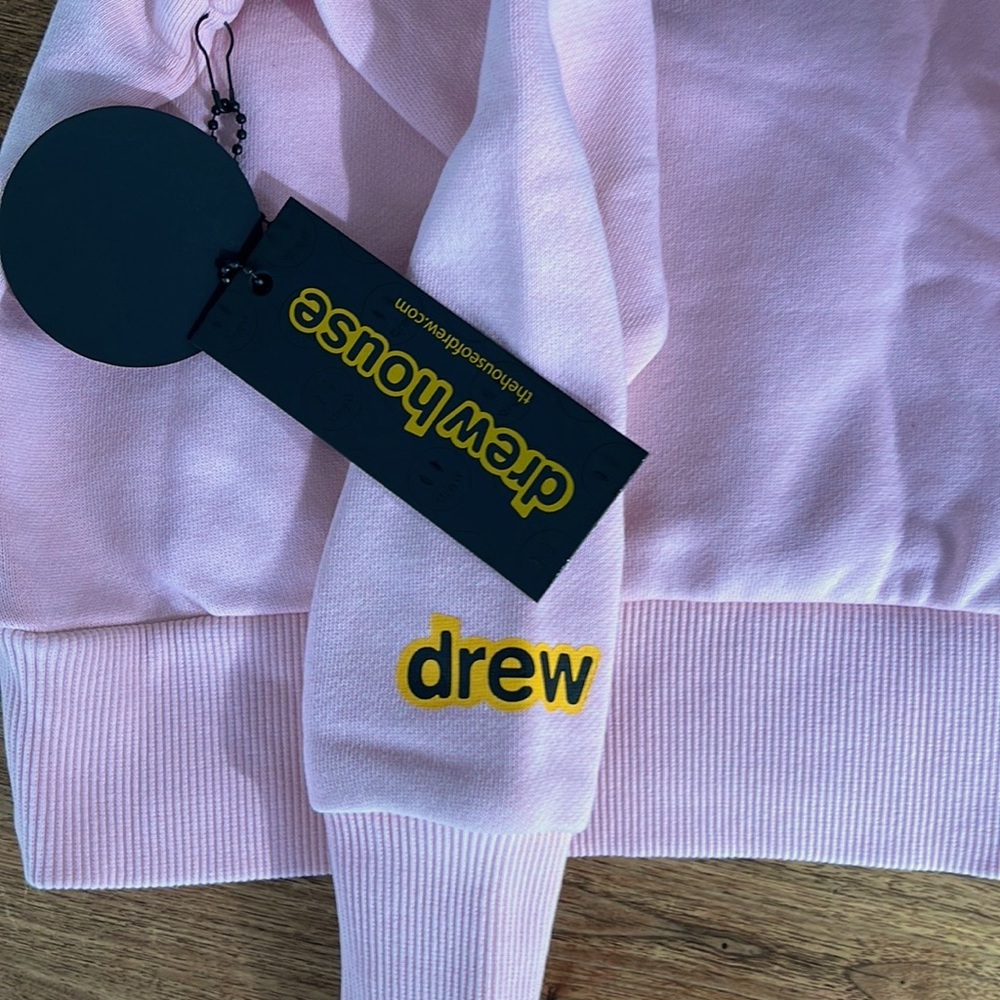 This sweatshirt is light pink from the brand DREW. It is a size 2 (kids).